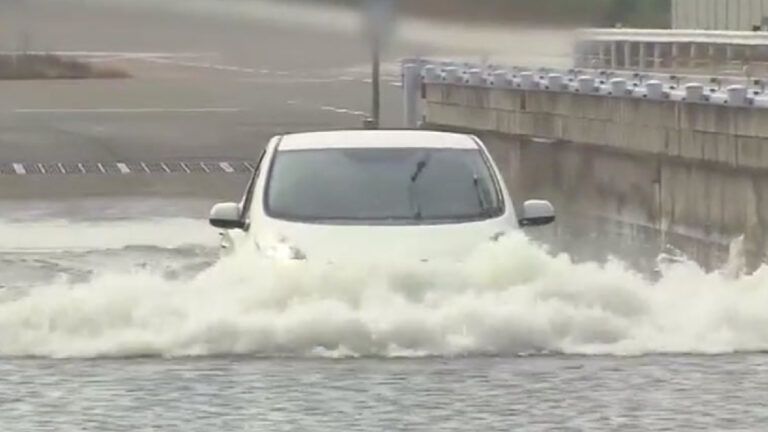 Electric car driving through deep water